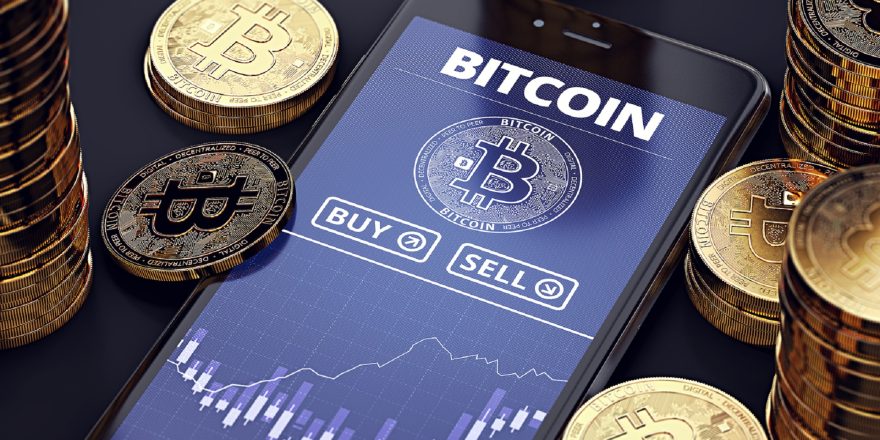 Smartphone with Bitcoin chart on-screen among piles of Bitcoins. Bitcoin trading concept. 3D rendering